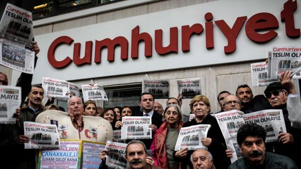 Protesters hold copies of the latest edition of the Turkish daily newspaper &quot;Cumhuriyet&quot; during a demonstration in support to the Cumhuriyet in front of its headquarters in Istanbul on November 1, 2016. Turkish police on October 31, 2016, detained the editor-in-chief of the newspaper Cumhuriyet -- a thorn in the side of President Recep Tayyip Erdogan -- as Ankara widens a crackdown on opposition media. The Cumhuriyet, which had published revelations embarrassing for the government, said at least a dozen journalists and executives were detained in early morning raids. Murat Sabuncu was detained while authorities searched for executive board chairman Akin Atalay and writer Guray Oz, the official news agency Anadolu said. / AFP PHOTO / YASIN AKGUL