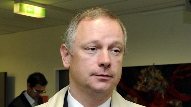 Ein Mann mit hellbraunem Haar blickt nach rechts.