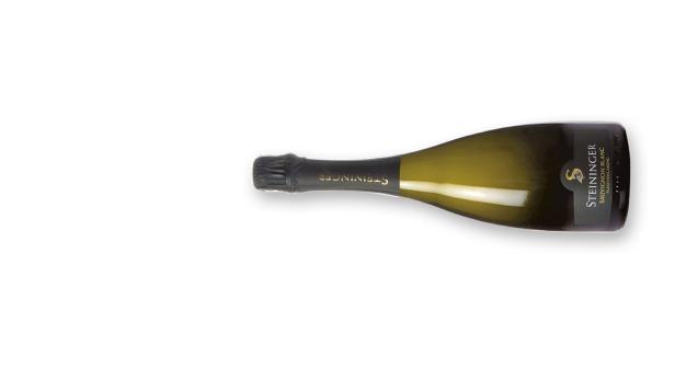 Eine Flasche Steininger Sauvignon Blanc Sekt liegt auf einer weißen Oberfläche.