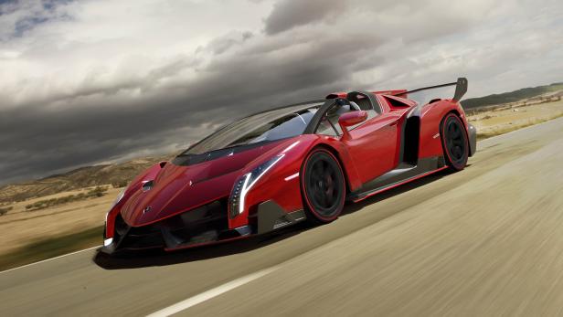 Ein roter Lamborghini Veneno fährt auf einer Landstraße.