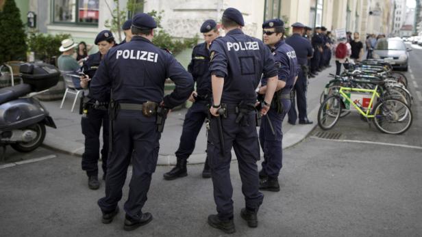 Eine Gruppe Polizisten steht auf einer Straße in Wien.