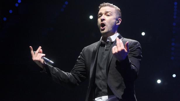 Justin Timberlake singt während eines Konzerts in einem schwarzen Anzug.