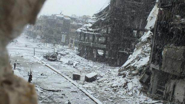 Snow falls over damaged buildings at Jouret al Shayah area in Homs January 9, 2013.REUTERS/Yazan Homsy (SYRIA - Tags: CIVIL UNREST POLITICS ENVIRONMENT TPX IMAGES OF THE DAY)