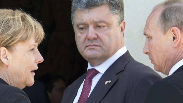 Angela Merkel, Petro Poroschenko und Wladimir Putin bei einem Treffen.