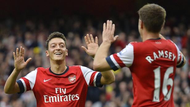 Mesut Özil und Aaron Ramsey geben sich ein High-Five auf dem Spielfeld.