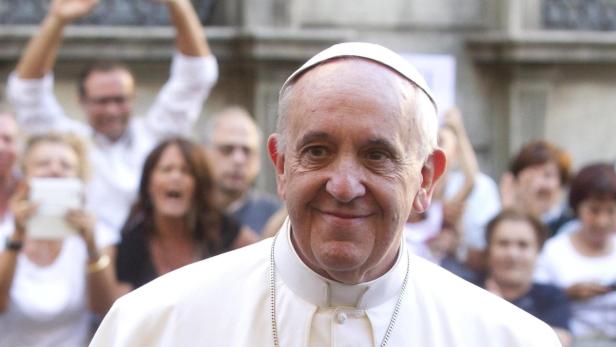 Papst Franziskus lächelt vor einer jubelnden Menschenmenge.