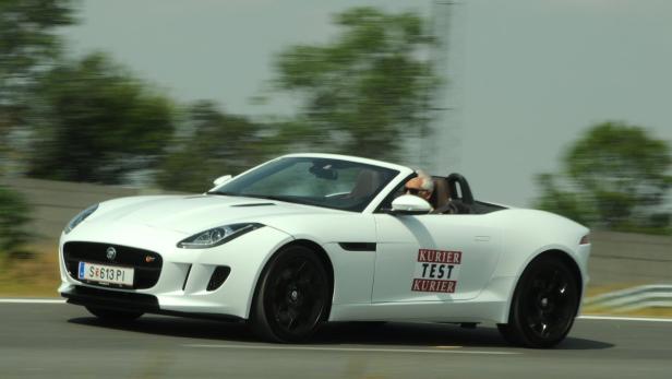 Ein weißer Jaguar F-Type Roadster fährt auf einer Teststrecke.