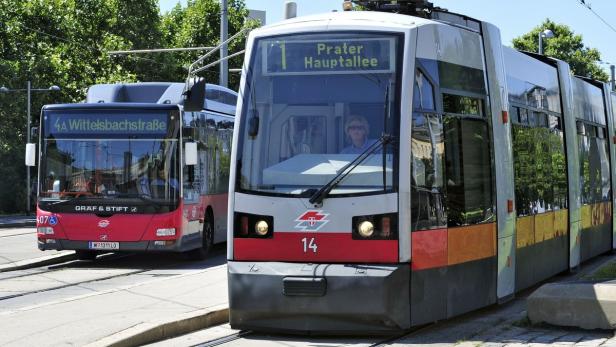 Eine Straßenbahn der Linie 1 „Prater Hauptallee“ und ein Bus der Linie 4A in Wien.
