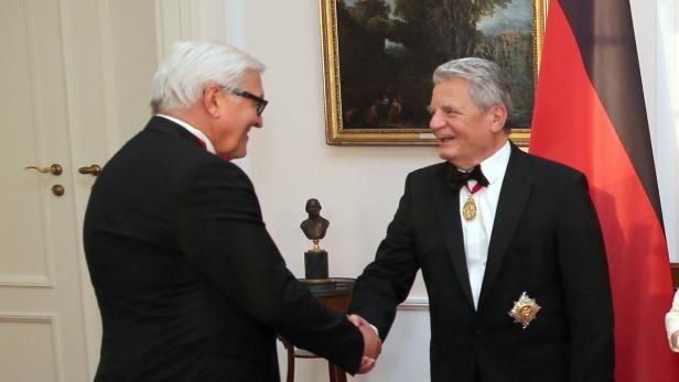 Frank-Walter Steinmeier, der Joachim Gauck die Hand gibt, deutsche Flagge im Hintergrund