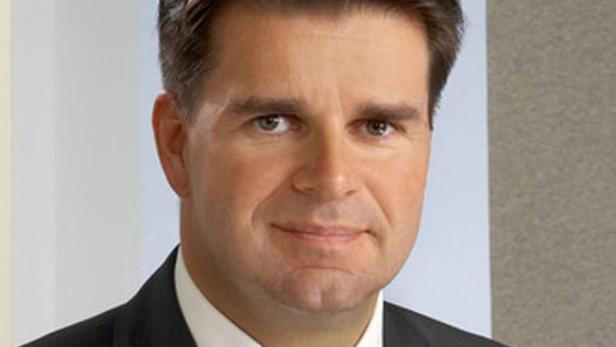 Porträt eines Mannes in einem dunklen Anzug.