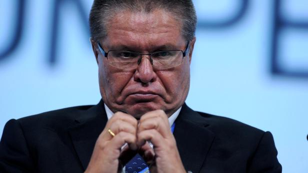 Ein Mann mit Brille und dunklem Anzug blickt ernst in die Kamera.