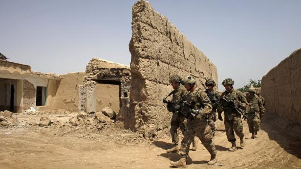 Eine Gruppe Soldaten patrouilliert durch eine zerstörte Stadt.