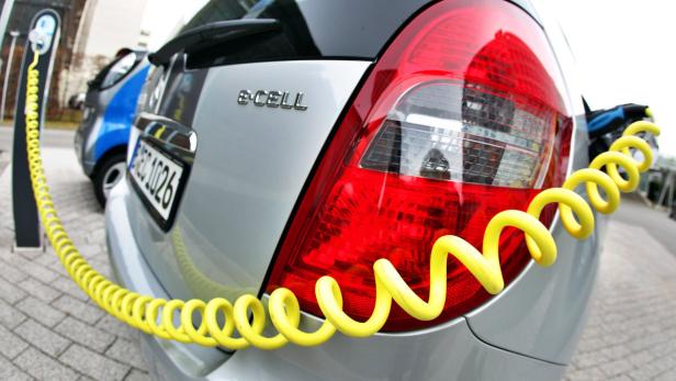 Ein silbernes Elektroauto vom Typ „e-CELL“ wird an einer Ladestation aufgeladen.