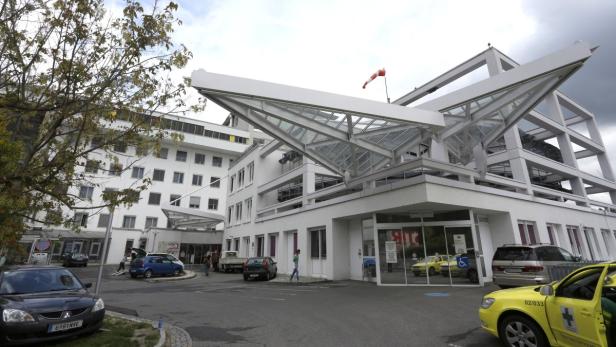 Das Landeskrankenhaus Steyr mit geparkten Autos vor dem Eingang.
