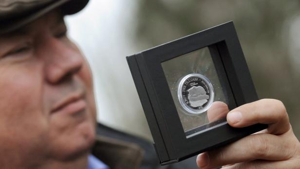 epa03141974 Zoo Director Bernhard Blaszkiewitz presents the &#039;Knut - der Traeumer Gedenkmuenze&#039; (lit.: Knut - The dreamer commemorative coin) at the Zoological Garden in Berlin, Germany, 12 March 2012. The front of the coin shows the Knut monument which will be set up at the zoo in summer whereas the back shows the emblem of Berlin. Polar bear Knut died on 11 March 2011. EPA/BRITTA PEDERSEN