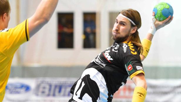 Ein Handballspieler mit langen Haaren wirft einen Ball.