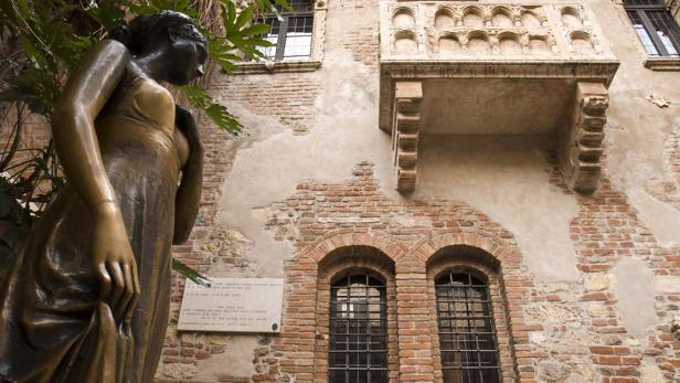 Eine Bronzestatue von Julia steht vor dem berühmten Balkon in Verona, Italien.