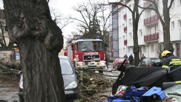 Firefighters stand near a car where one person was killed and three injured when a tree fell onto it during a storm nicknamed &quot;Emma&quot; in St. Poelten March 1, 2008. REUTERS/FF St. Poelten-Stadt/Handout (AUSTRIA). FOR EDITORIAL USE ONLY. NOT FOR SALE FOR MARKETING OR ADVERTISING CAMPAIGNS..