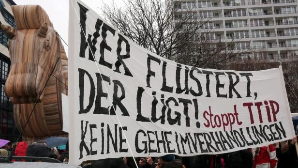Demonstranten mit einem Trojanischen Pferd und einem Banner gegen TTIP.