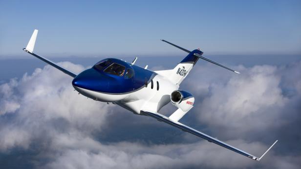Ein HondaJet-Flugzeug fliegt über einer Wolkendecke.