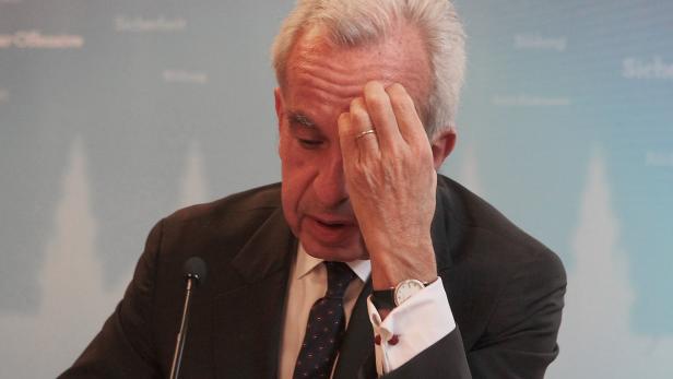 Ein Mann in Anzug und Krawatte hält sich die Hand an die Stirn.