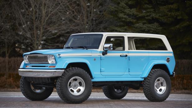 Ein hellblaues und weißes Jeep-Cabriolet steht auf einer gepflasterten Fläche.
