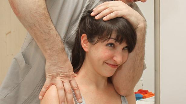 Ein Mann behandelt den Nacken einer Frau.