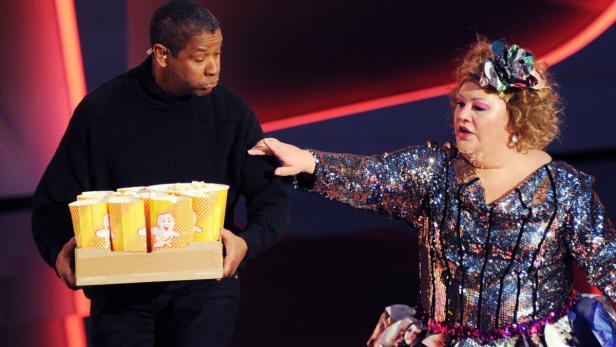 epa03545552 US actor Denzel Washington (L) reacts as German comedian &#039;Cindy aus Marzahn&#039; (R) advances to grab a bag of popcorn which Washington offered to guests and candidates of the German TV show &#039;Wetten, dass..?&#039; (&#039;Bet, that ...&#039;) in Offenburg, Germany, late 19 January 2013. Washington was guest and patron of one of the show&#039;s bets. EPA/ULI DECK