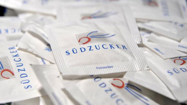 Viele kleine Päckchen Feinzucker der Marke Südzucker liegen übereinander.
