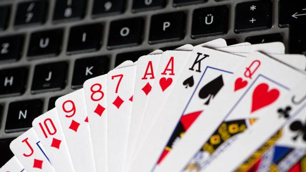 Spielkarten liegen auf einer Computertastatur.