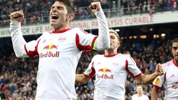 Ein jubelnder Fußballspieler im Trikot von Red Bull vor einer Zuschauermenge.