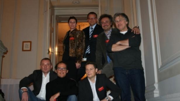 Eine Gruppe von sieben Personen posiert auf einer Treppe für ein Foto.