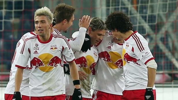 Fußballspieler von Red Bull Salzburg feiern gemeinsam auf dem Spielfeld.