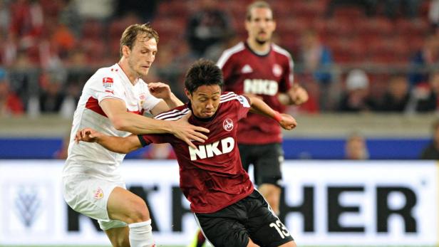 Zwei Fußballspieler kämpfen um den Ball während eines Spiels.