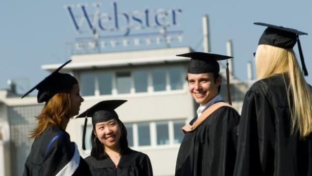 Eine Gruppe von Absolventen der Webster University in ihren Talaren und Hüten.