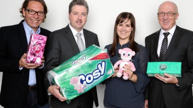 Vier Personen präsentieren Produkte, darunter Toilettenpapier und Kosmetiktücher.