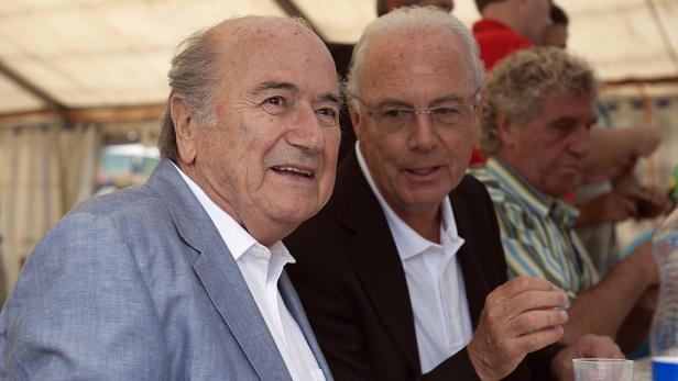 Sepp Blatter und Franz Beckenbauer sitzen zusammen an einem Tisch.