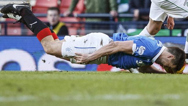 Ein Fußballspieler liegt nach einem Zweikampf auf dem Rasen.