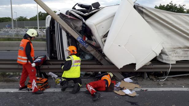 Ein verunglückter LKW liegt auf der Seite, während Rettungskräfte vor Ort sind.
