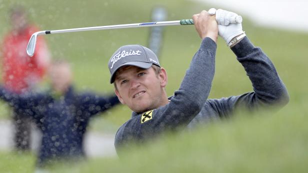 Ein Golfspieler schlägt einen Ball aus einem Bunker.