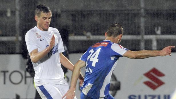Zwei Fußballspieler während eines Spiels im Regen.