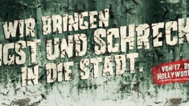 „Wir bringen Angst und Schrecken in die Stadt“ steht auf einer verwitterten Wand, Ankündigung für ein Event im Hollywood Megaplex.
