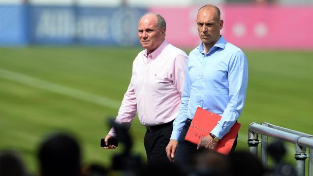 Uli Hoeneß und ein weiterer Mann stehen auf einem Fußballplatz.