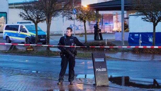 Polizisten sichern in Flensburg das Gelände in der Nähe eines Supermarktes.