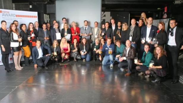 Eine Gruppe von Menschen posiert mit dem „Vamp Award“ für ein Gruppenfoto.