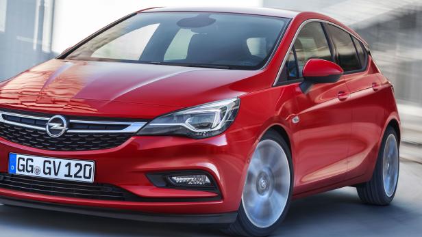 Ein roter Opel Astra fährt auf einer Straße.