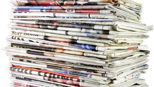 Ein hoher Stapel von Zeitungen liegt übereinander.