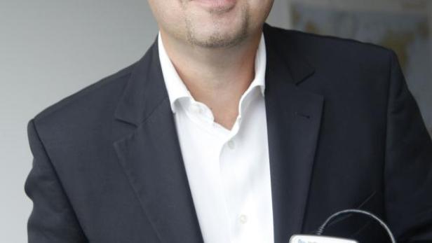 Ein Mann im Anzug hält ein Kartenlesegerät und eine Kreditkarte in der Hand.