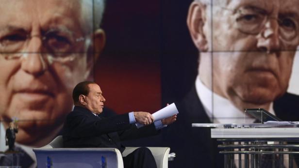 epa03513508 Italy&#039;s former Prime Minister and leader of Italian &#039;Popolo della Liberta&#039; (People of Freedom) party, Silvio Berlusconi, speaks during the recording of the Italian Rai 1 television program &#039;Porta a porta&#039; hosted by journalist Bruno Vespa (unseen), in Rome, Italy, 18 December 2012. Seen in background is a projection of incumbent Itailan Prime Minister Mario Monti. Berlusconi earlier in December announced plans to run again for premier - complicating elections due in 2013 and setting off alarm bells on financial markets and EU in Brussels. Berlusconi left office in 2011 amid a flurry of legal investigations and a struggling economy, handing the reins to technocratic Prime Minister Mario Monti, who since then has worked on enabling Italy to pull back from the brink of its economic woes. EPA/GUIDO MONTANI