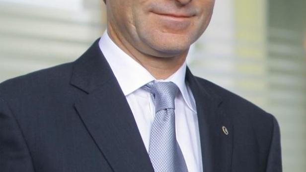 Ein Mann im Anzug blickt in die Kamera.